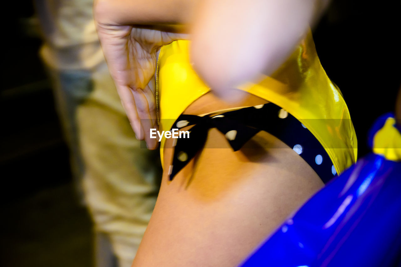 CLOSE-UP OF WOMAN HAND WITH YELLOW HAIR STANDING