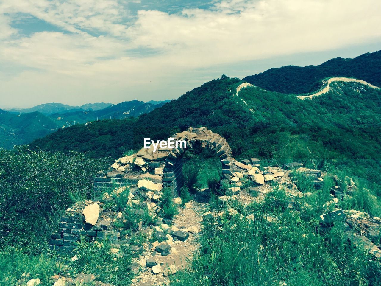 HIGH ANGLE VIEW OF STATUE AGAINST MOUNTAIN RANGE