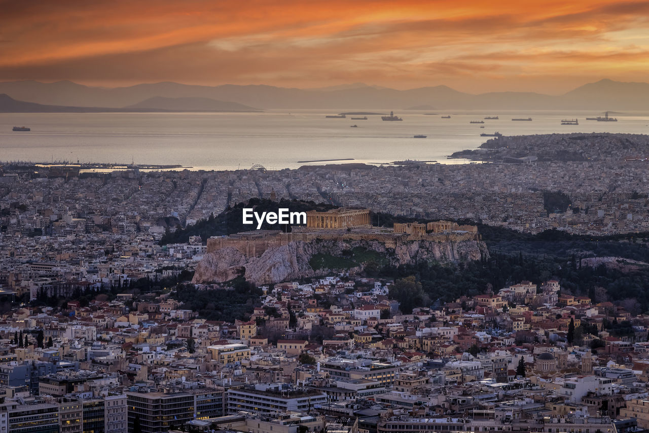 HIGH ANGLE VIEW OF TOWNSCAPE BY SEA AGAINST SKY