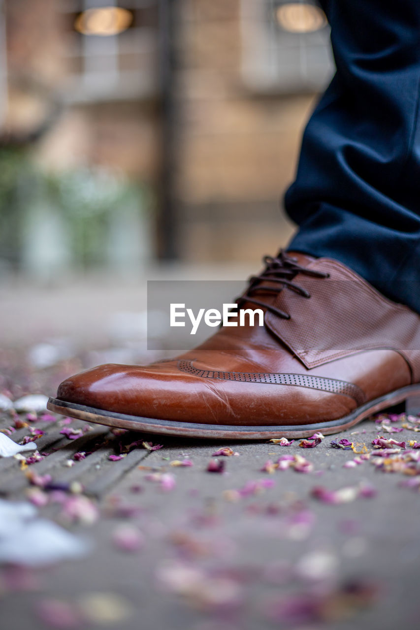 Low section of man standing on street, brown leather shoe on the wedding day