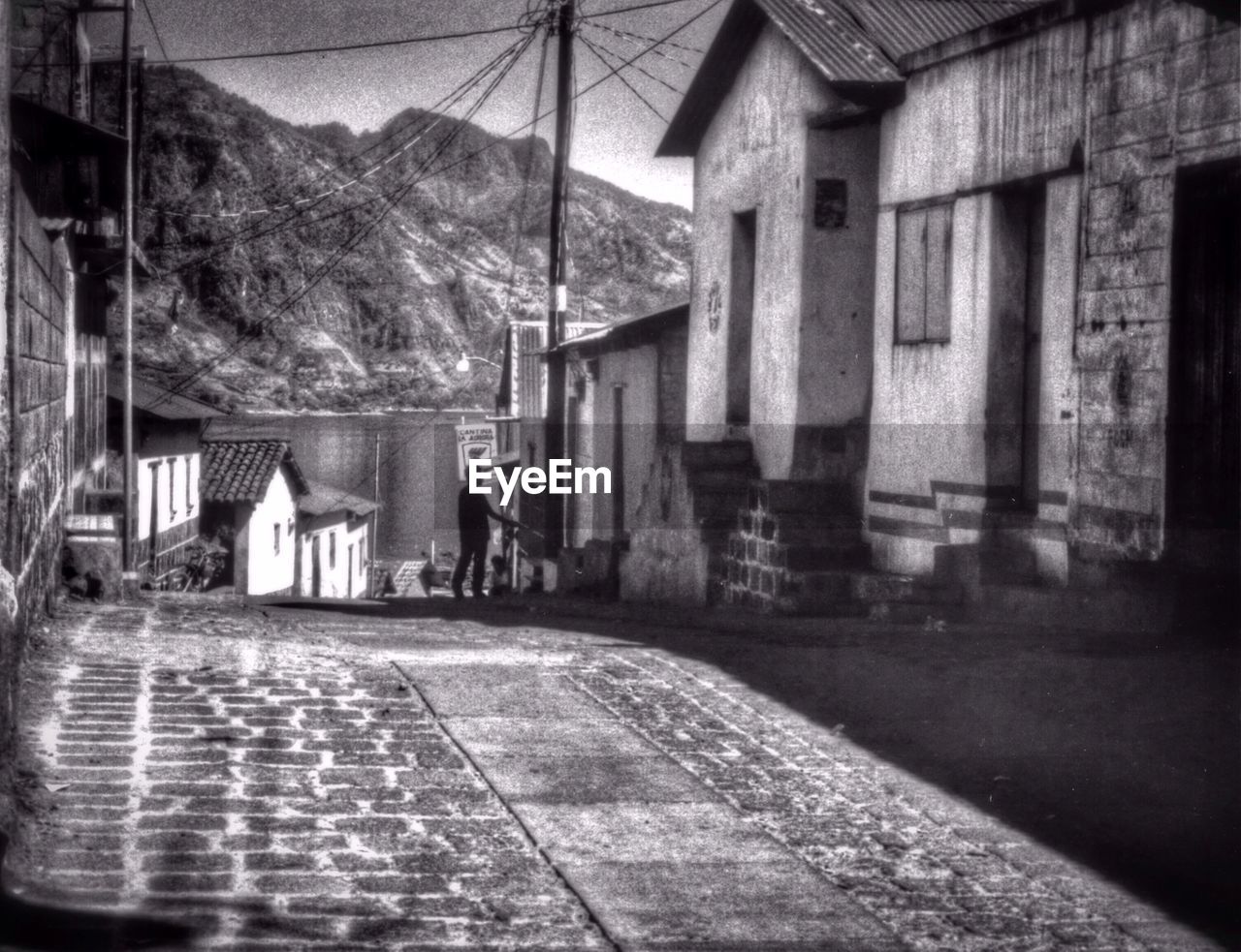 Street amidst buildings against mountains