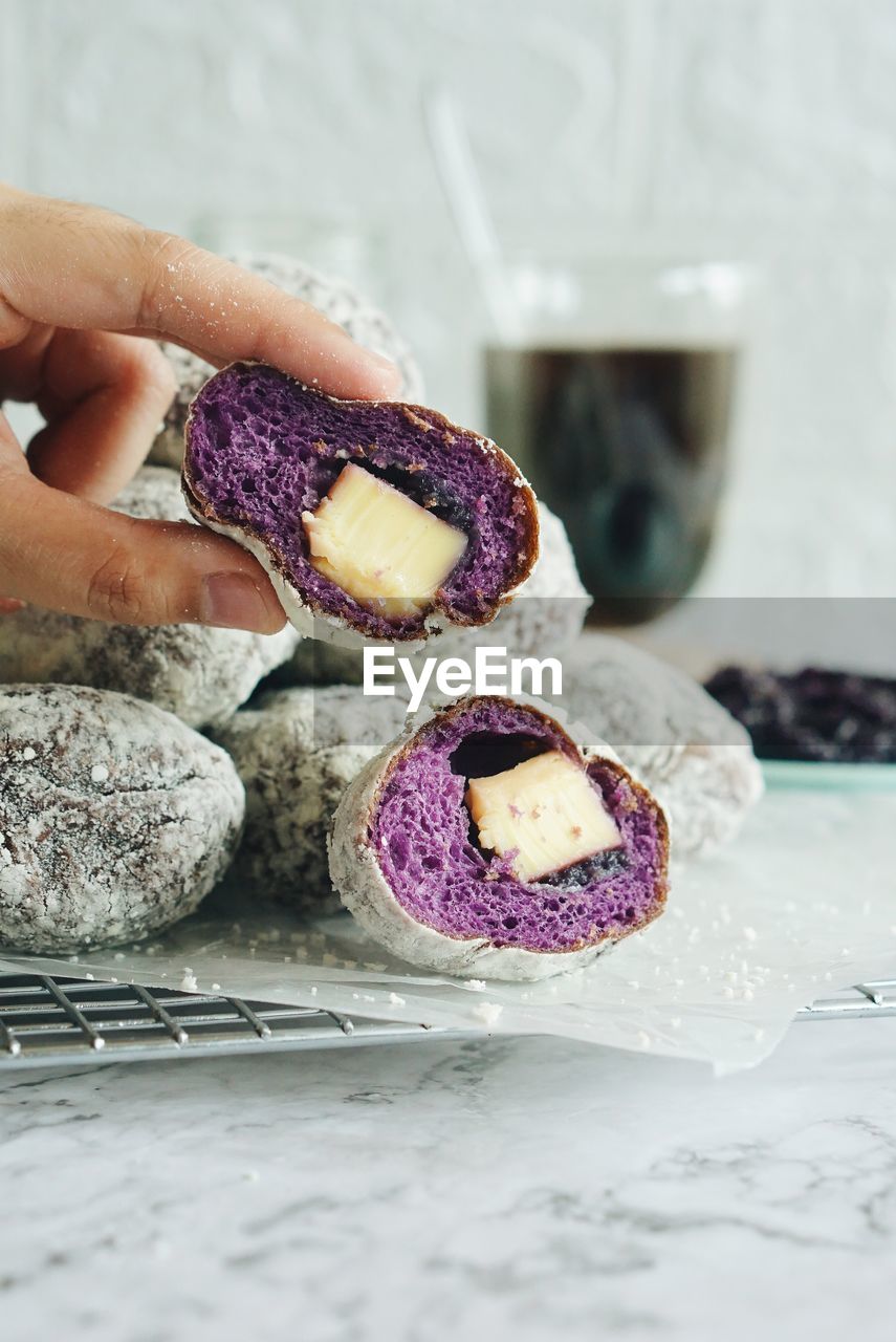 Close-up of hand holding donut on table