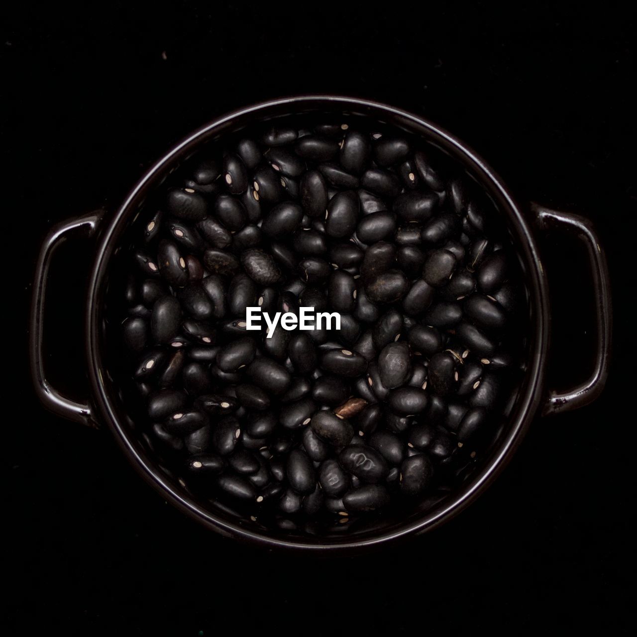 Close-up view of black turtle beans in bowl on black background