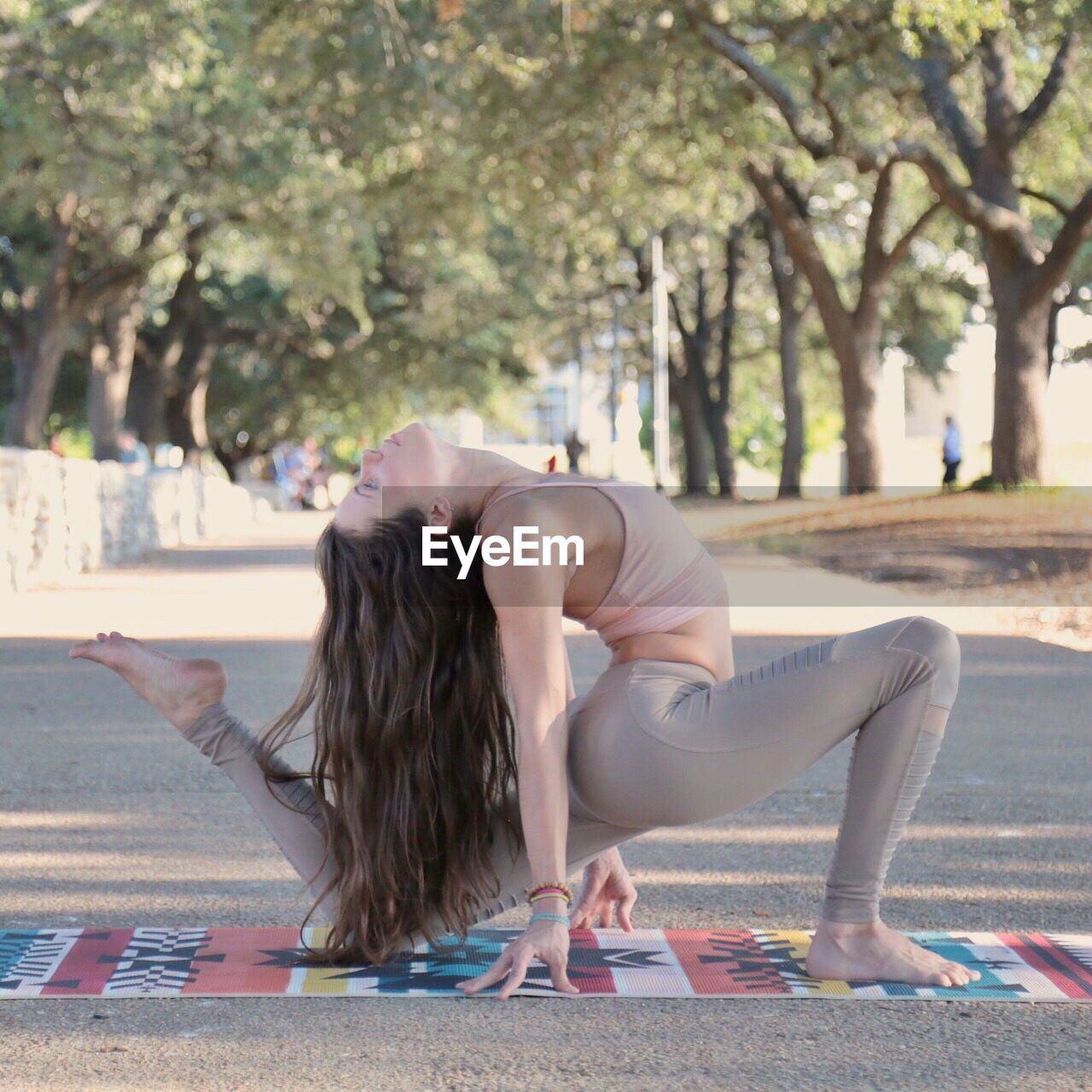 WOMAN SITTING ON BENCH IN PARK