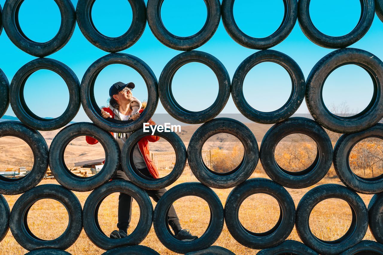 Full frame shot of man climbing outdoor play equipment made of tires
