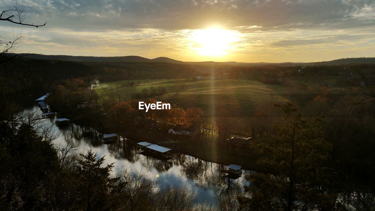 Scenic view of agricultural landscape against sky during sunset