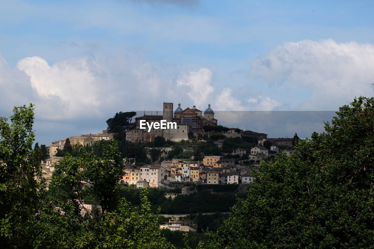 VIEW OF TOWN AGAINST CLOUDY SKY