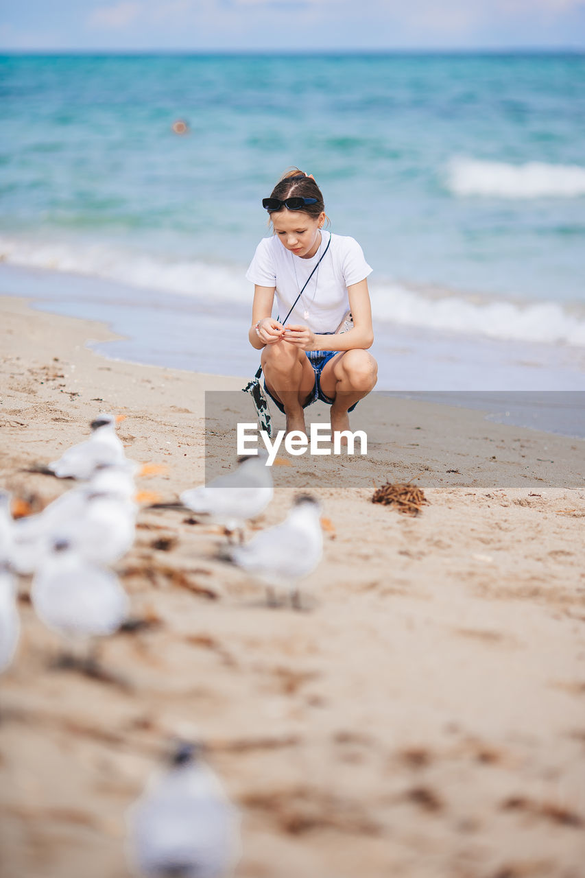 rear view of woman sitting on beach