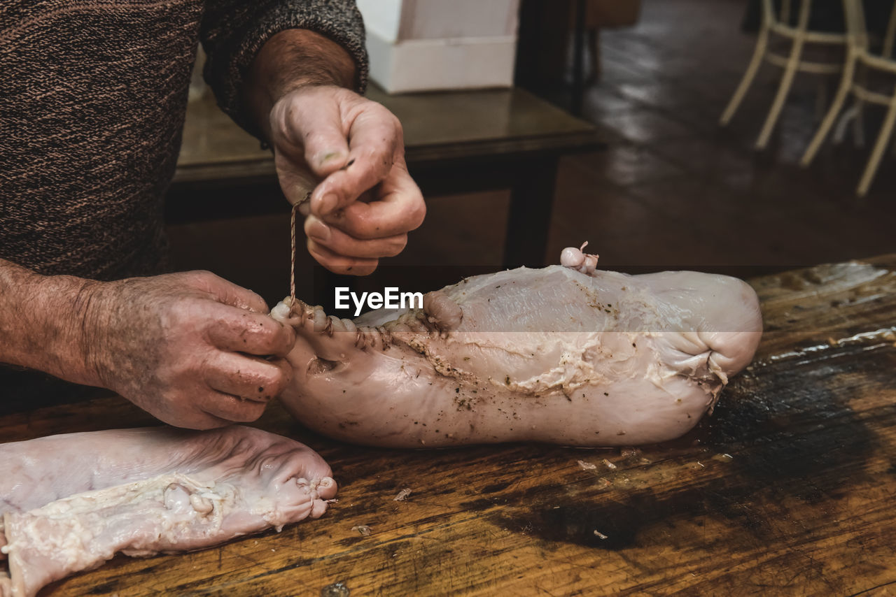 cropped hand of man preparing food on cutting board