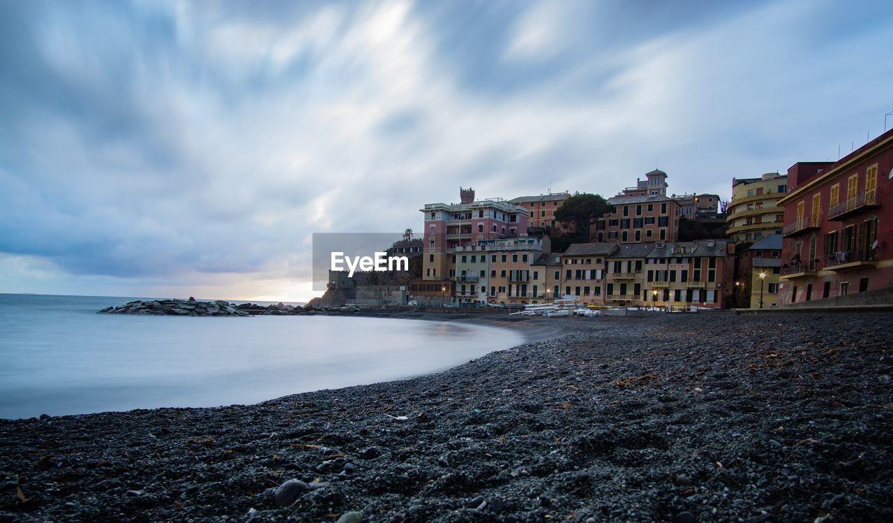 Buildings by sea against sky