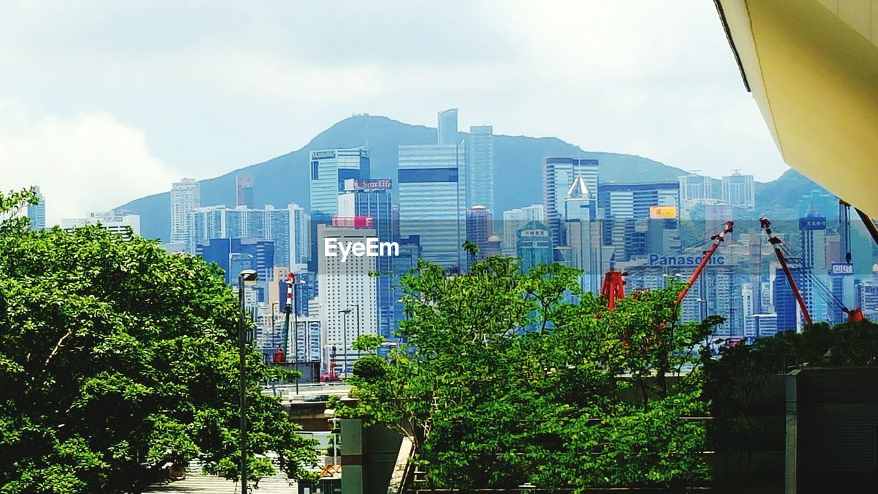 LOW ANGLE VIEW OF MODERN BUILDING AGAINST CLOUDY SKY