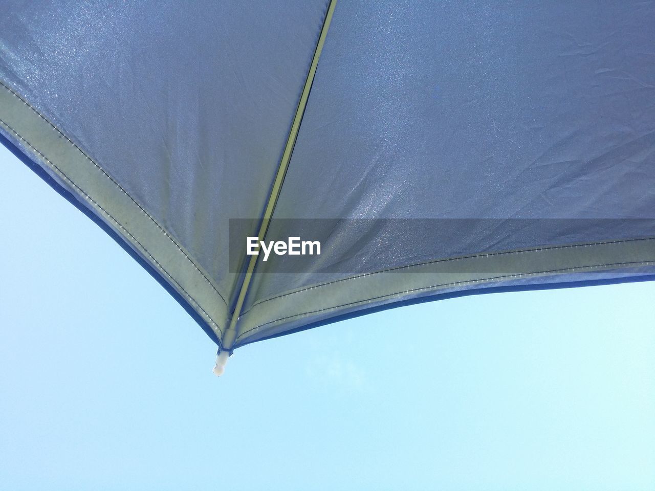 Low angle view of umbrella against clear blue sky