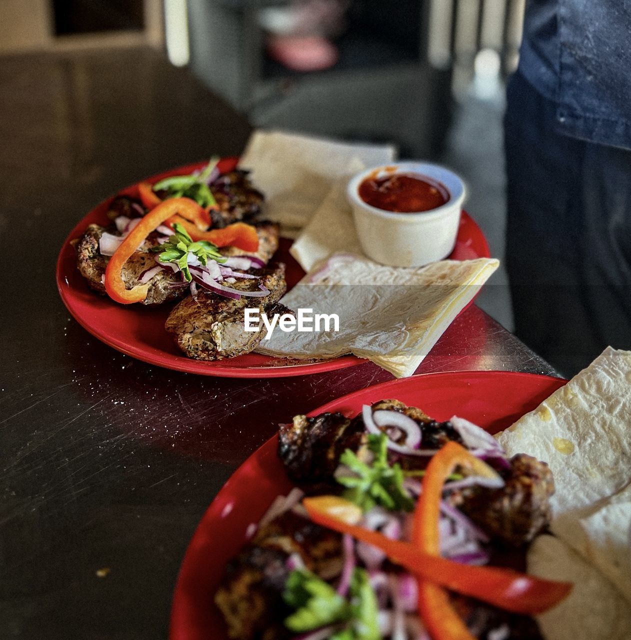 food and drink, food, fast food, freshness, healthy eating, vegetable, meal, table, dish, lunch, plate, indoors, wellbeing, clothing, restaurant, high angle view, one person, business, cuisine, meat, selective focus, salad, tomato, fruit, taco