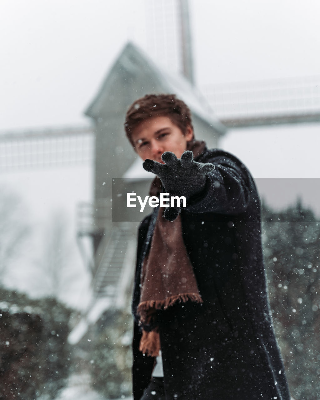 Portrait of man gesturing while standing in snow