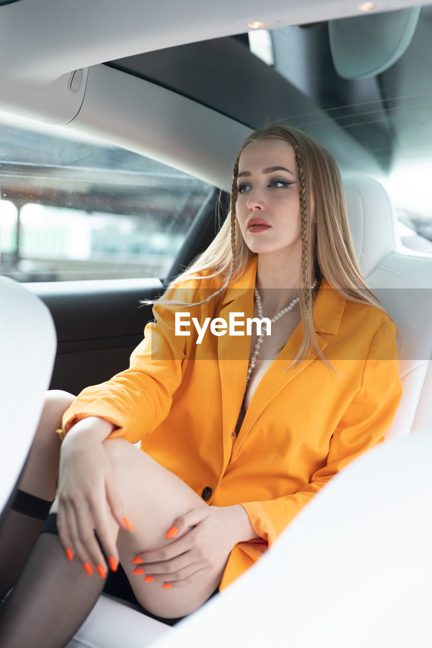 Portrait of young woman sitting in car