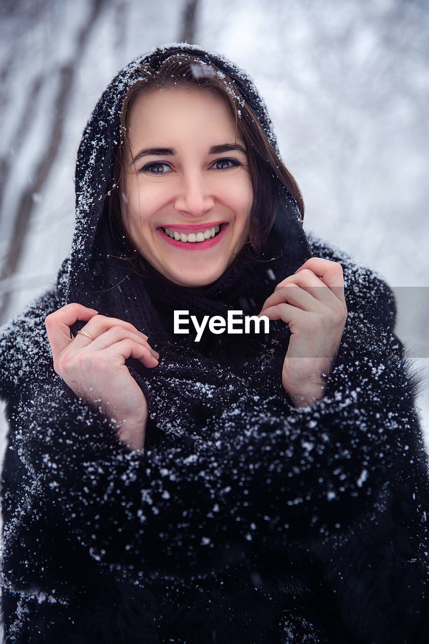 Portrait of a smiling young woman in snow