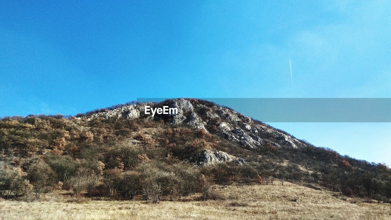 LOW ANGLE VIEW OF MOUNTAIN RANGE AGAINST CLEAR BLUE SKY