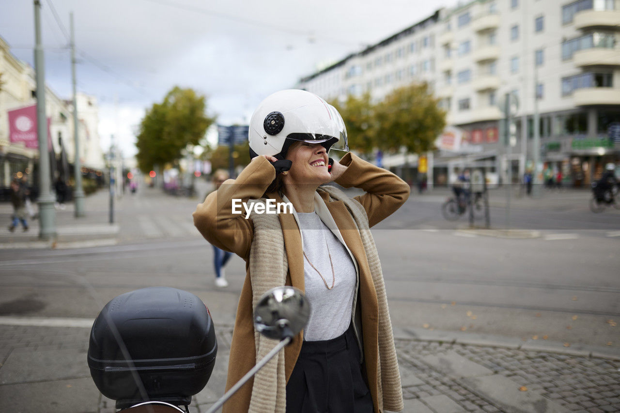 Woman putting on motorcycle helmet