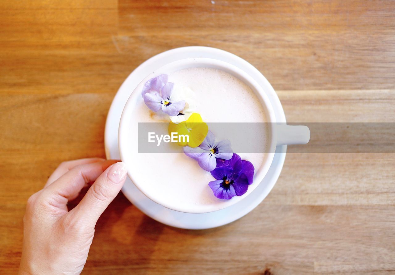 CLOSE-UP OF HAND HOLDING ICE CREAM IN PLATE