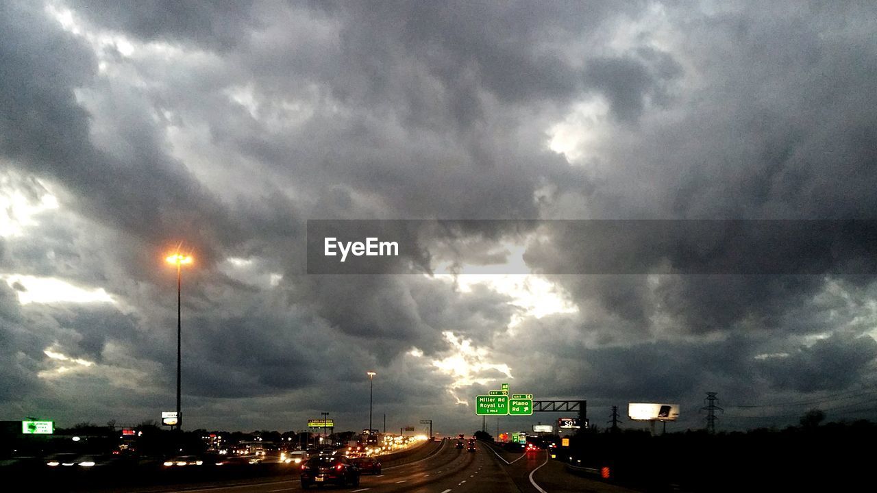 TRAFFIC ON ROAD AGAINST DRAMATIC SKY