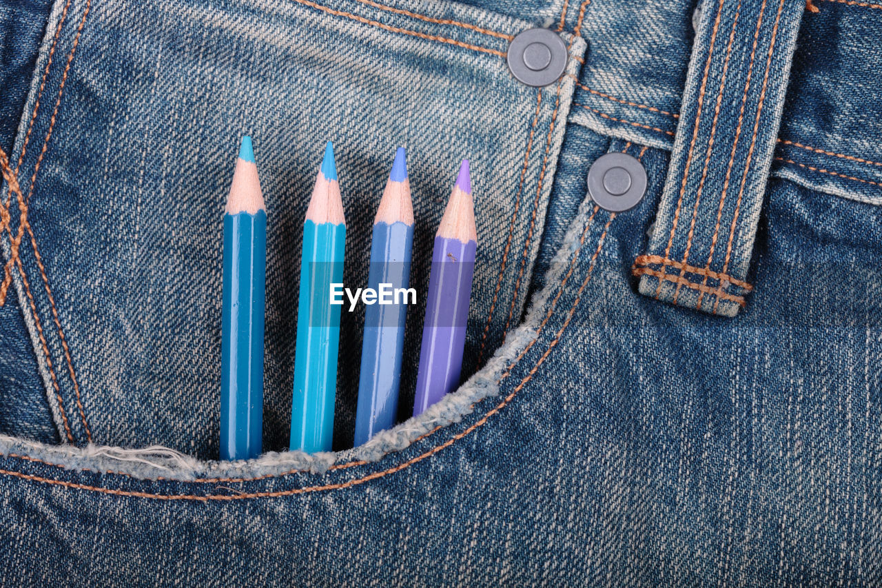 Close-up of multi colored pencils in jeans