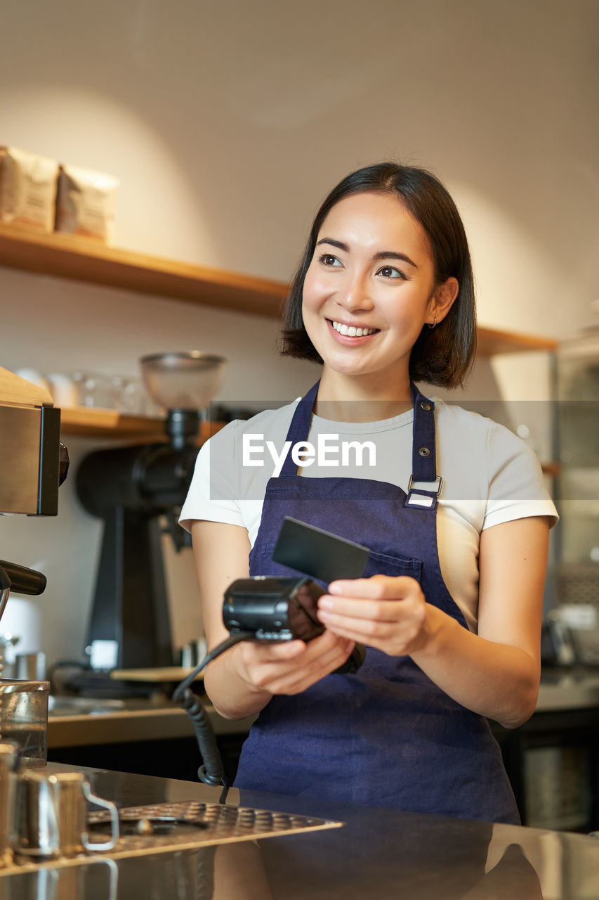 portrait of smiling young woman using mobile phone