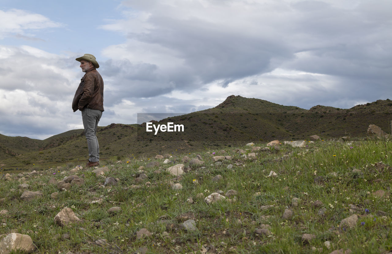 Portrait of adult man in cowboy hat on field