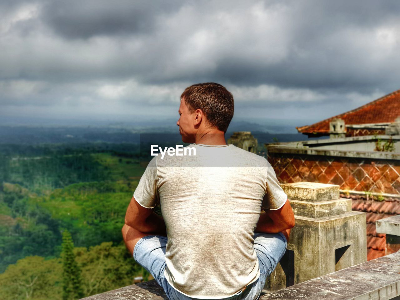 Rear view of man looking at mountains against sky