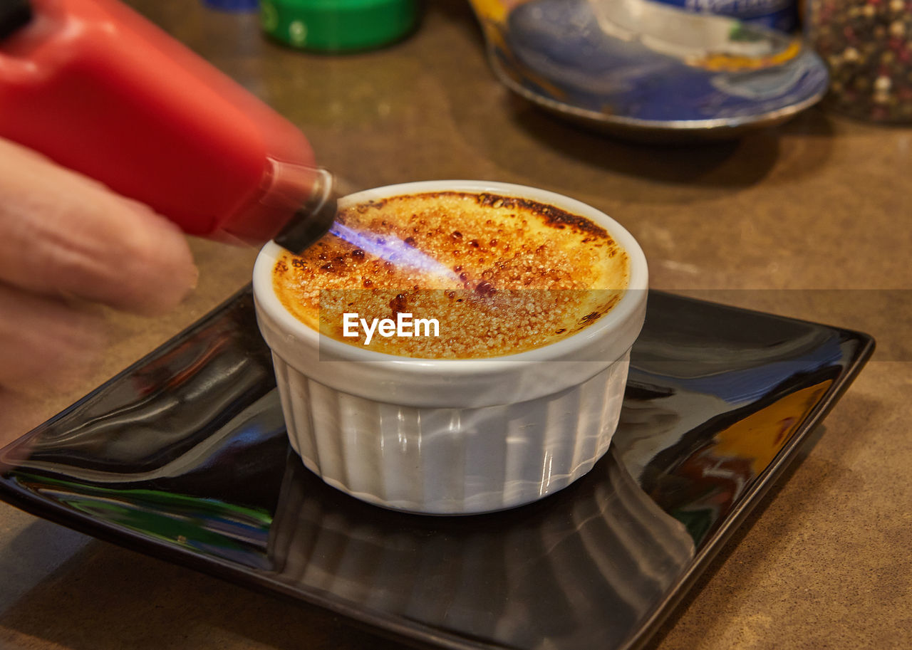 Creme brulee with mushrooms in special form, the chef burns sugar with burner. french gourmet 