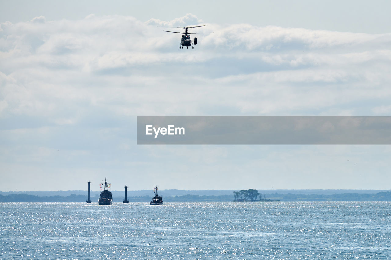 Battleships war ships corvette during naval exercises and helicopter maneuvering over water