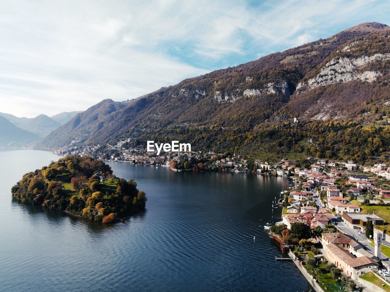 Scenic view of como lake townscape by mountains against sky