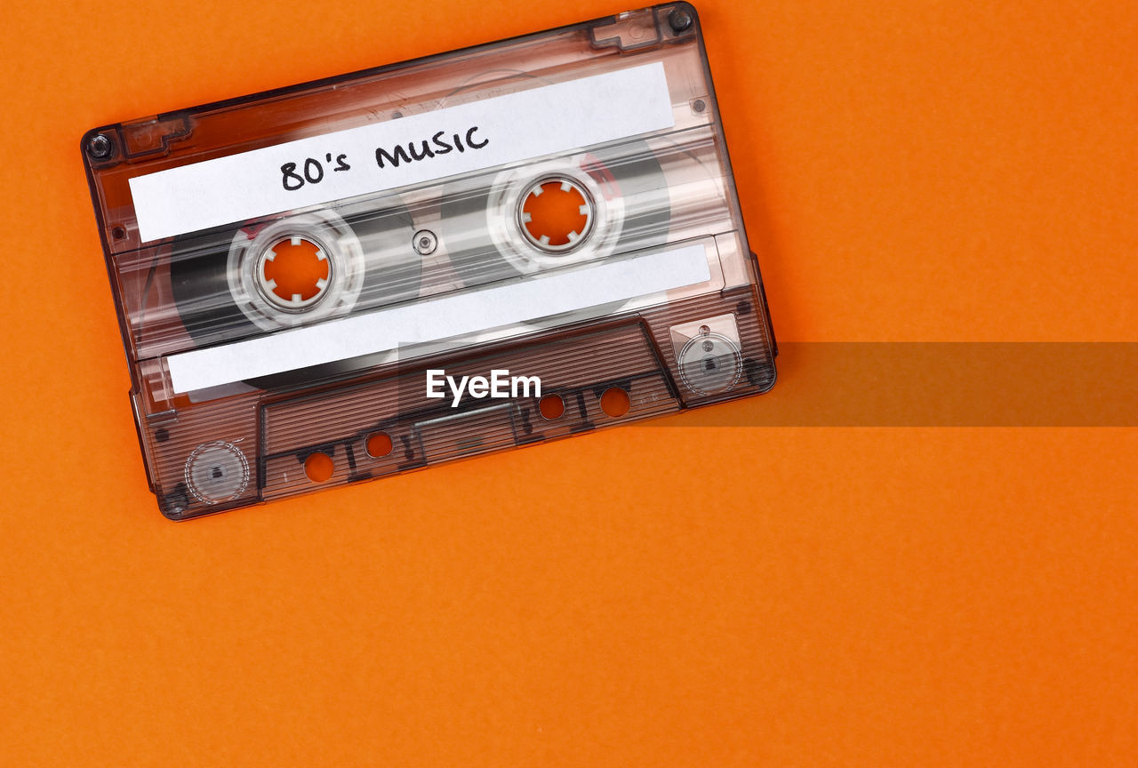 Close-up of cassette tape against orange background