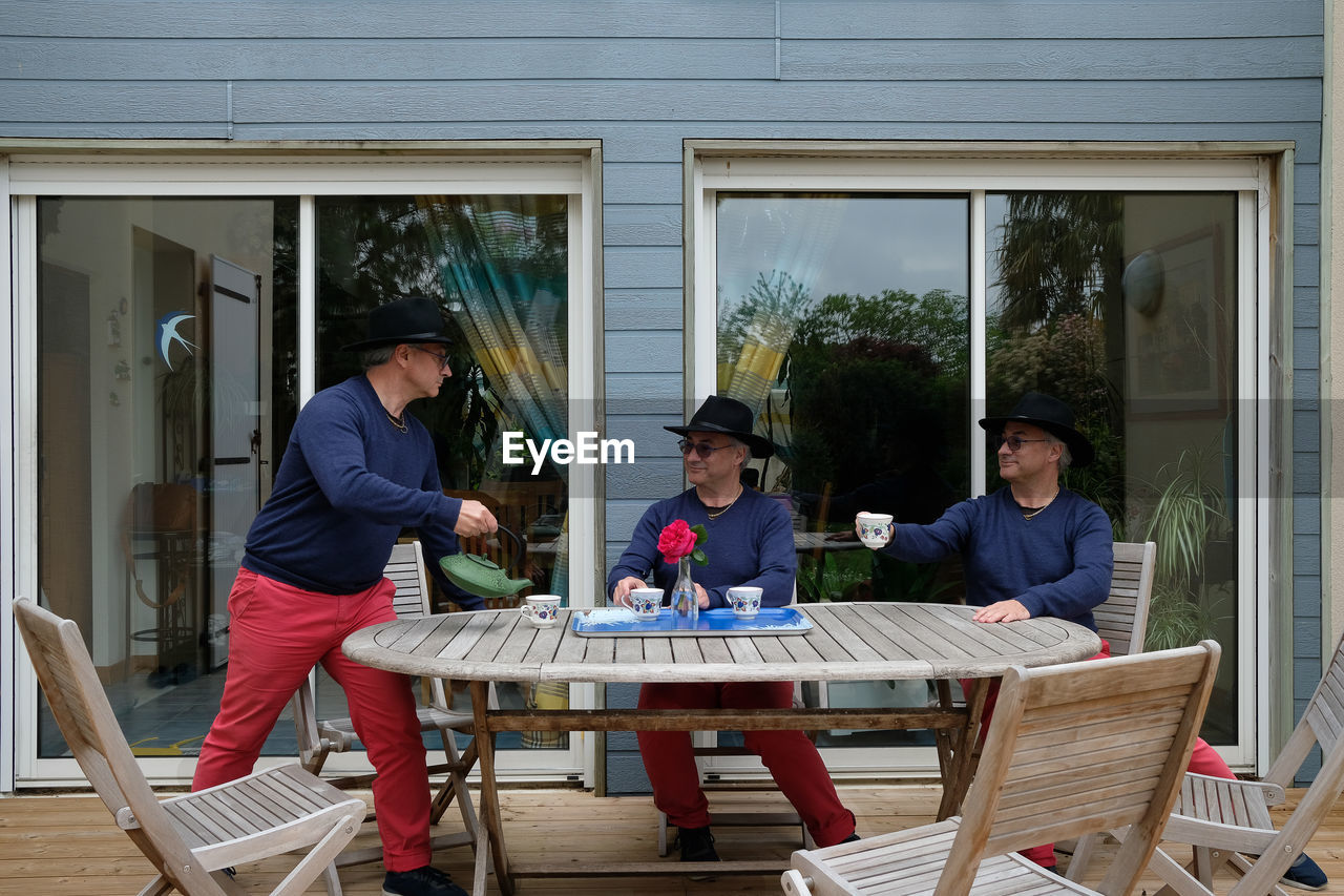 GROUP OF PEOPLE SITTING ON CHAIR