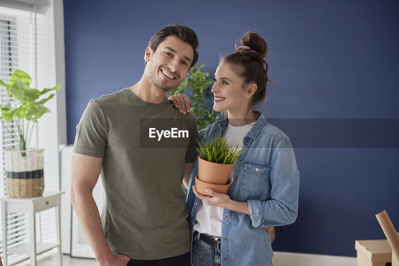 YOUNG COUPLE STANDING AGAINST THE BLUE SKY