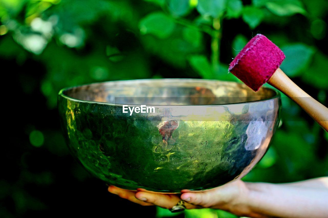 Close-up of human hand holding rin gong outdoors