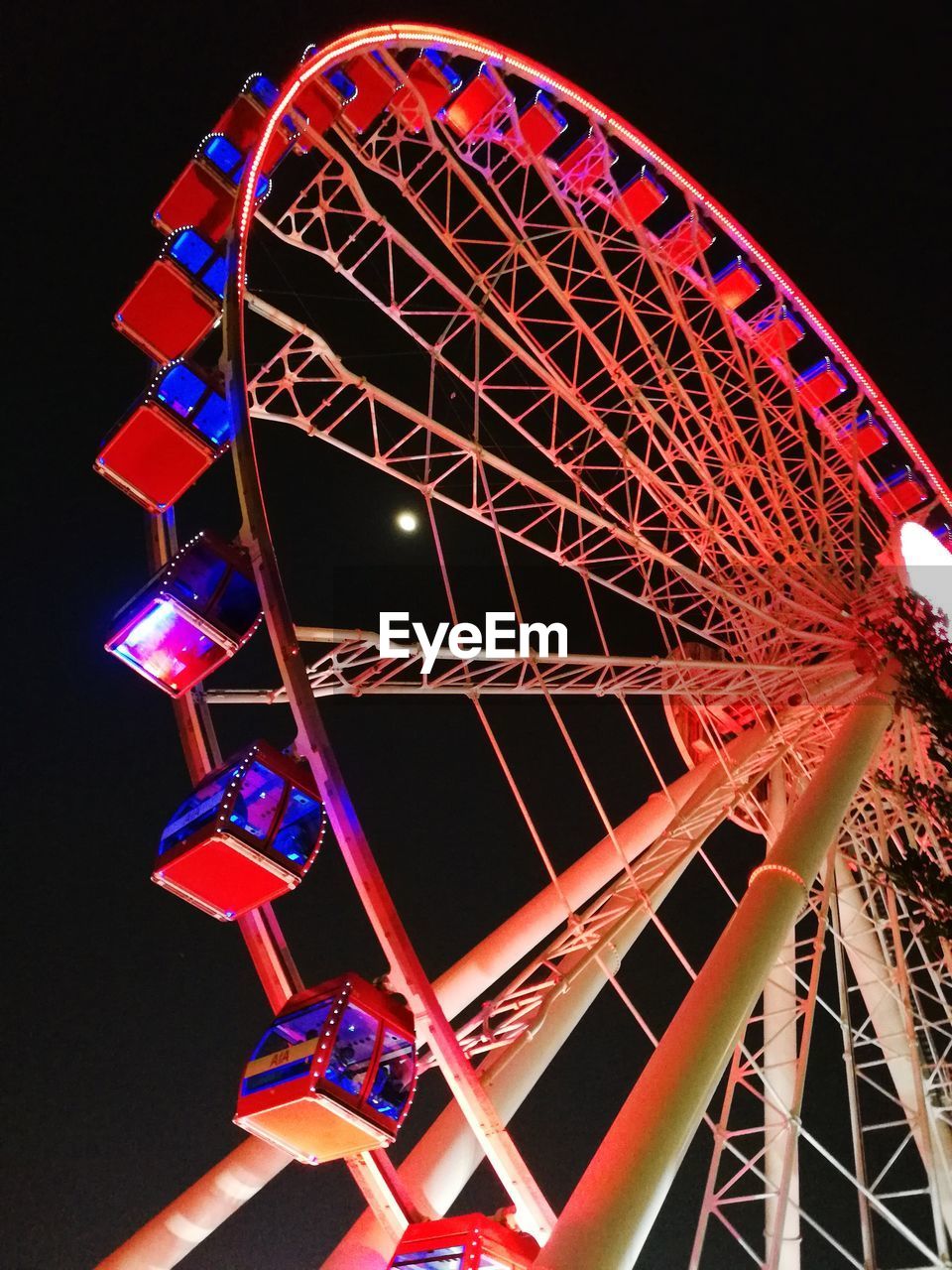 LOW ANGLE VIEW OF ILLUMINATED FERRIS WHEEL AT NIGHT