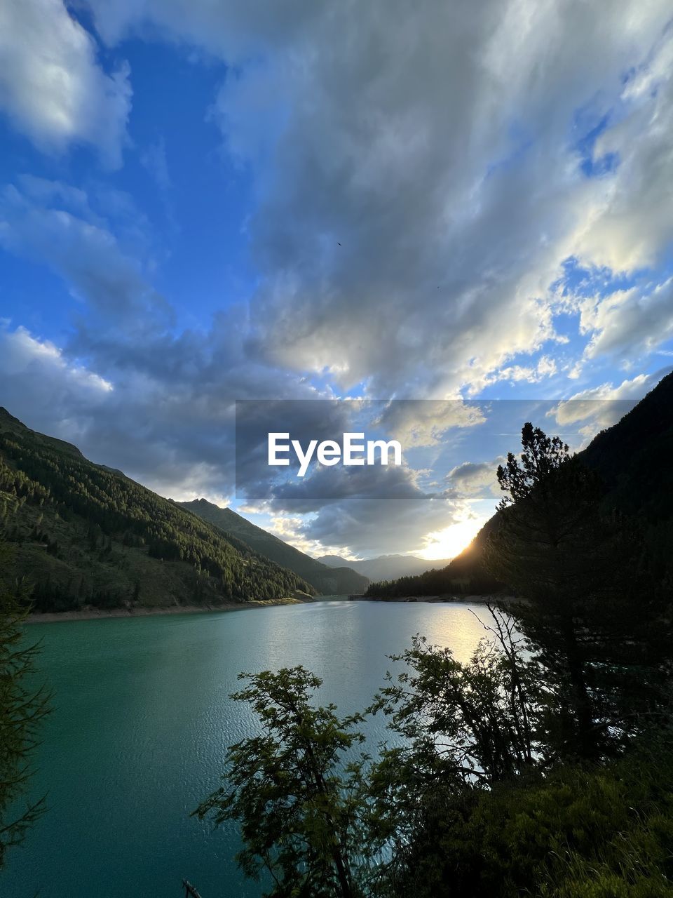 sky, cloud, sunlight, reflection, nature, beauty in nature, scenics - nature, tree, environment, light, plant, water, no people, outdoors, landscape, land, blue, mountain, travel, panoramic, travel destinations, tranquility, forest