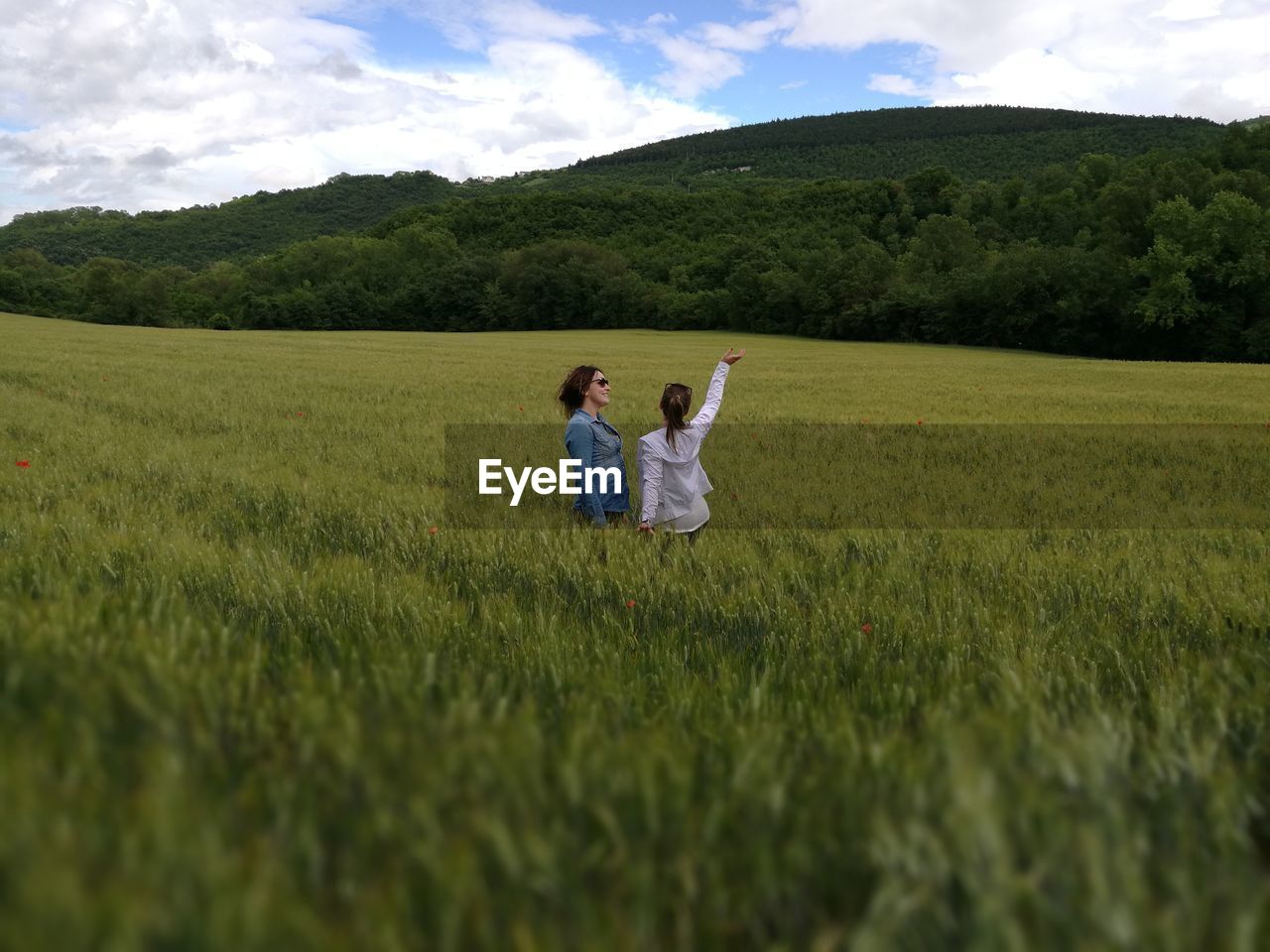 Scenic view of grassy field against cloudy sky