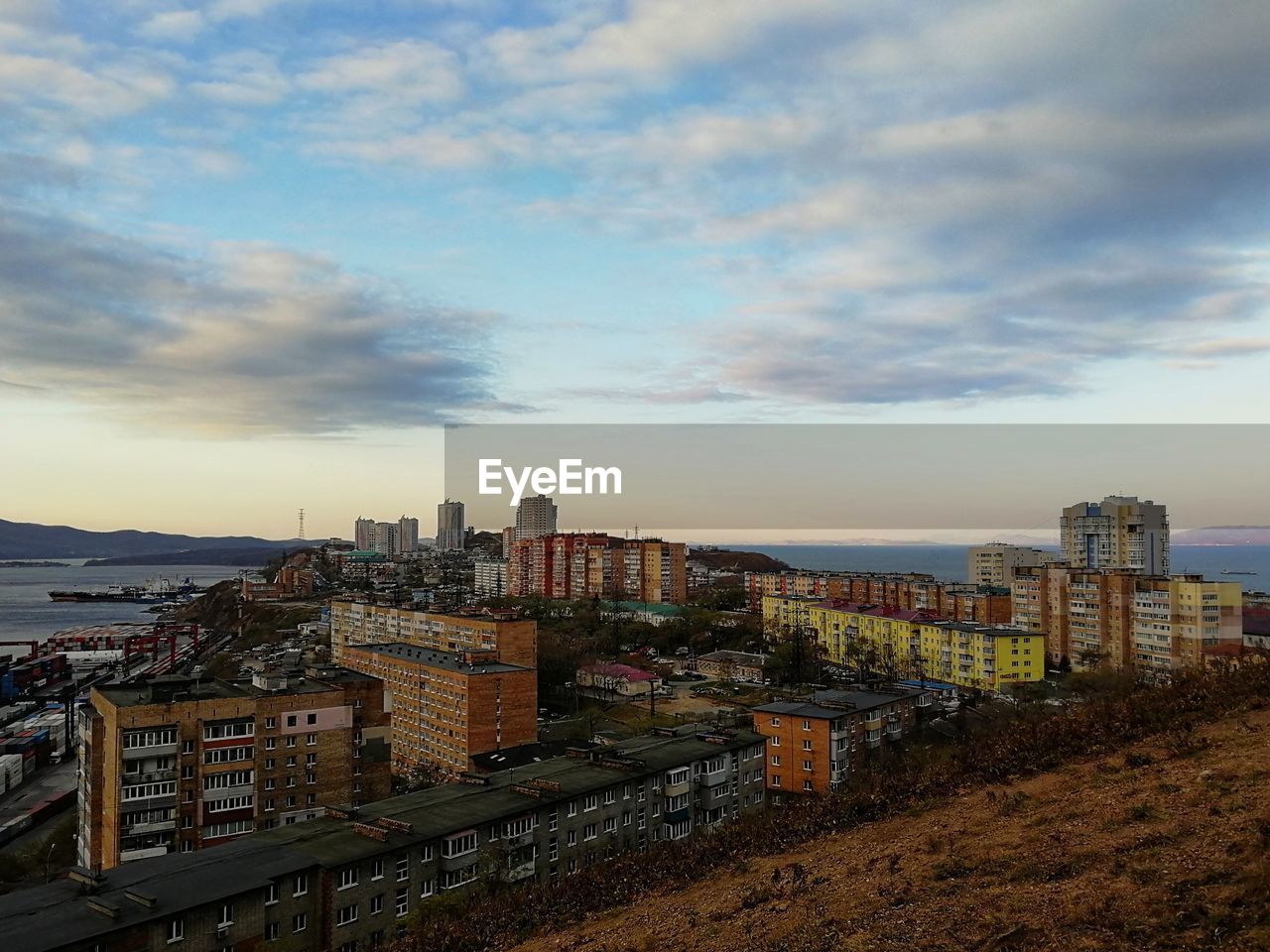 HIGH ANGLE VIEW OF BUILDINGS AGAINST SKY AT SUNSET