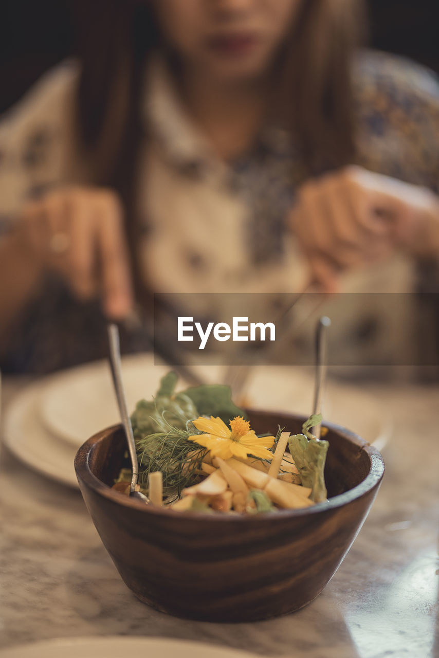 Close-up of woman holding salad in bowl