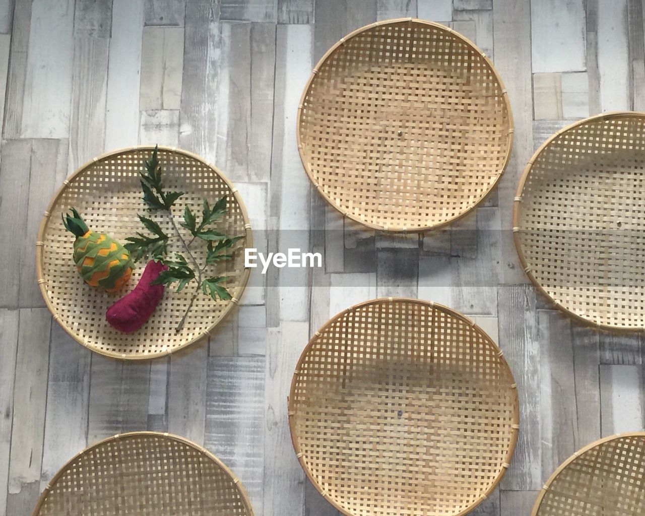 Directly above view of toy vegetables in bamboo plate on tiled floor