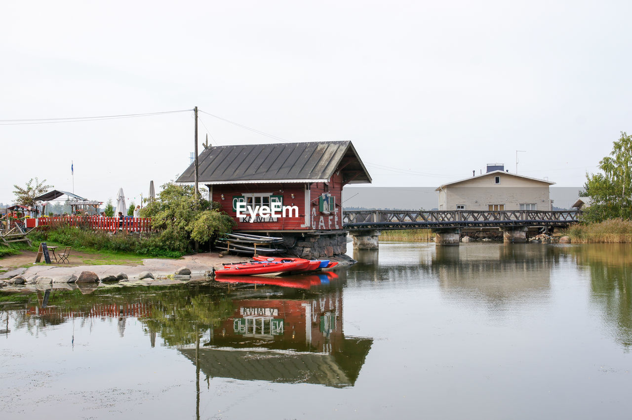 TRADITIONAL BUILDING BY LAKE AGAINST SKY