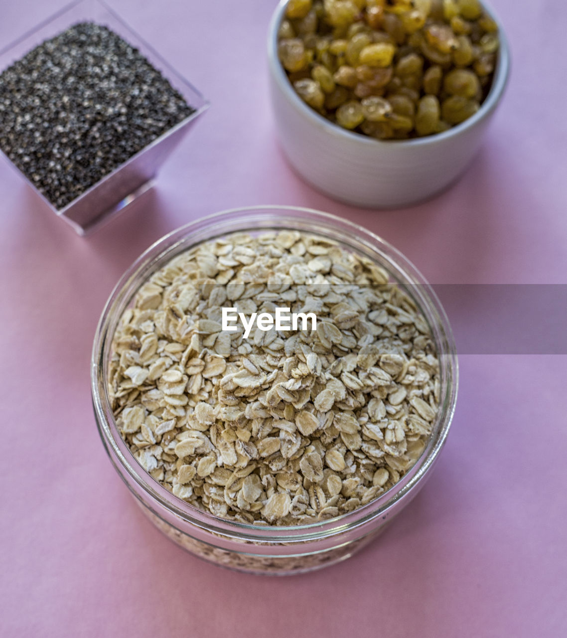 High angle view of oats and raisins in containers on table