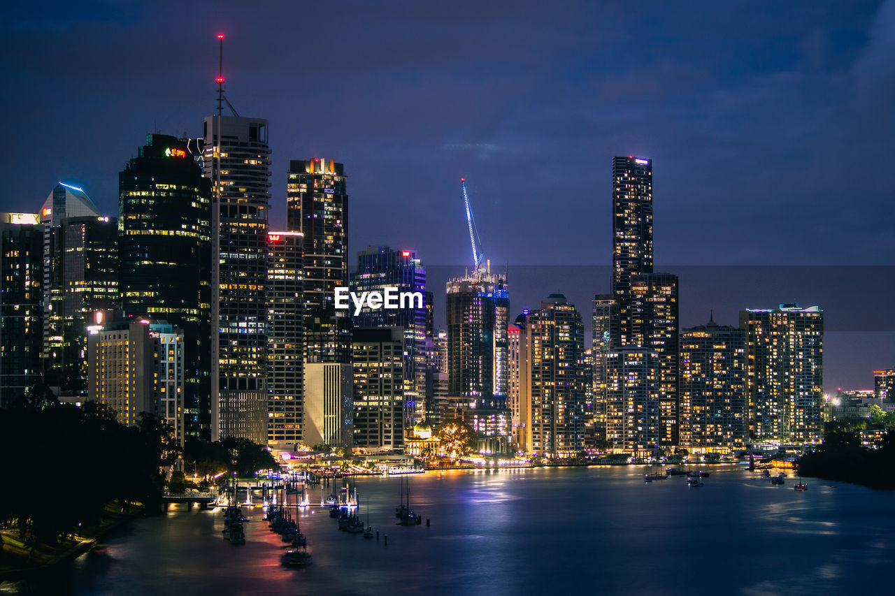 Illuminated buildings in city against sky at night