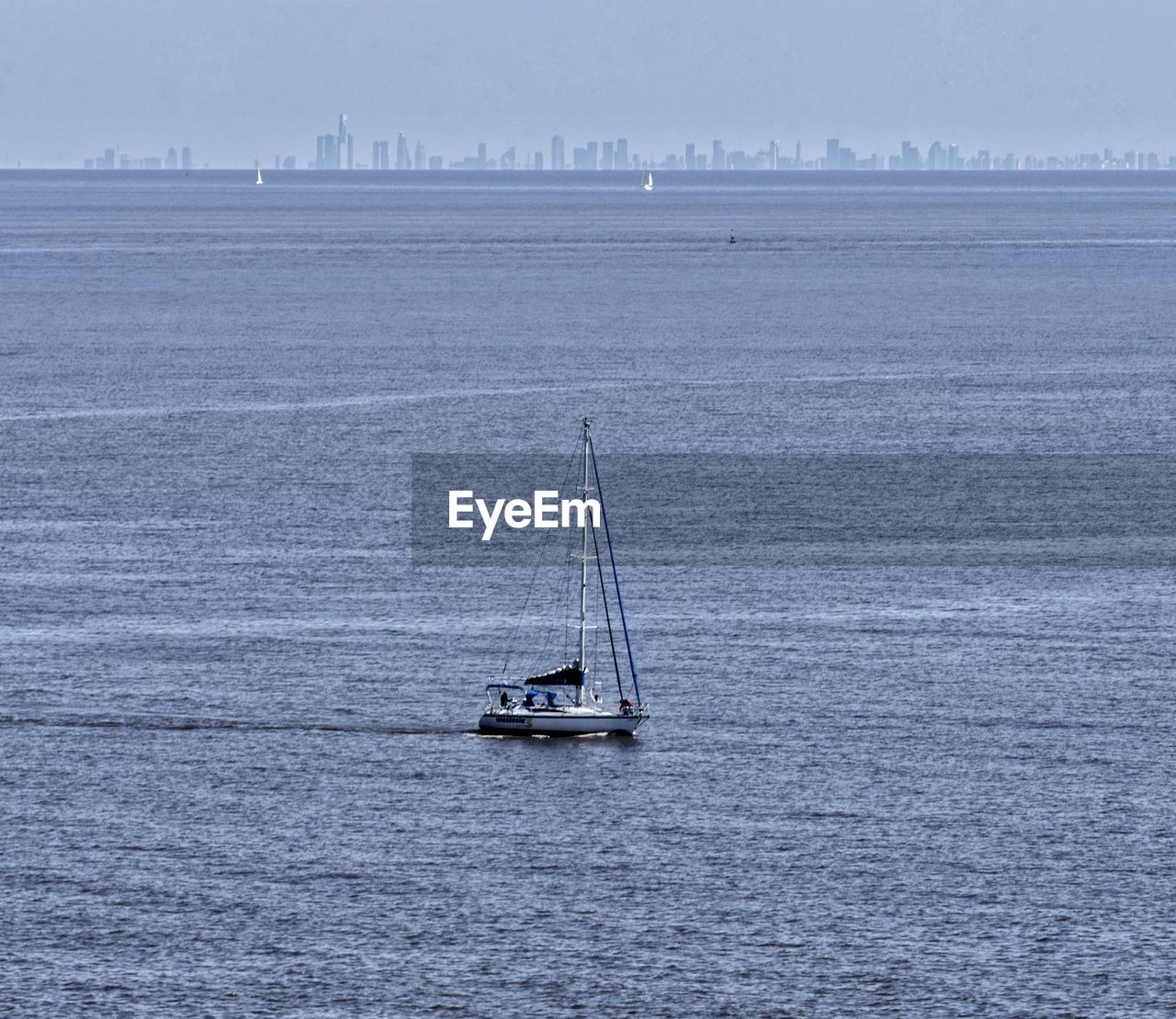 Sailboat sailing on river against sky