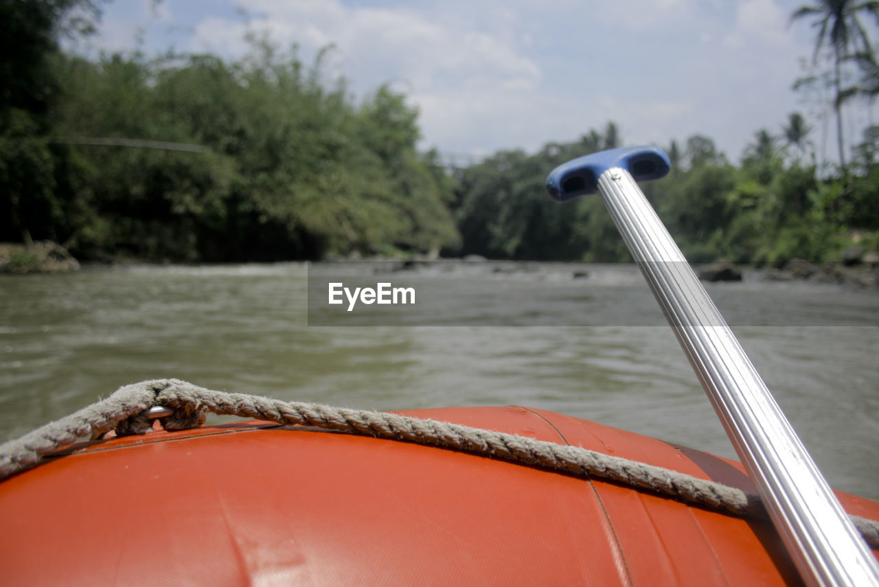 Close-up of boat on river against trees