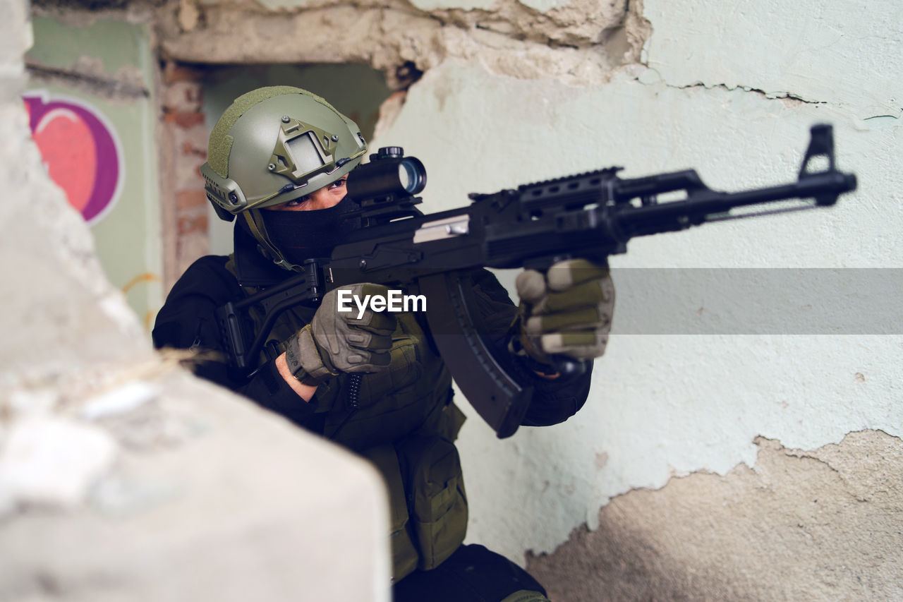 Army soldier aiming gun in building