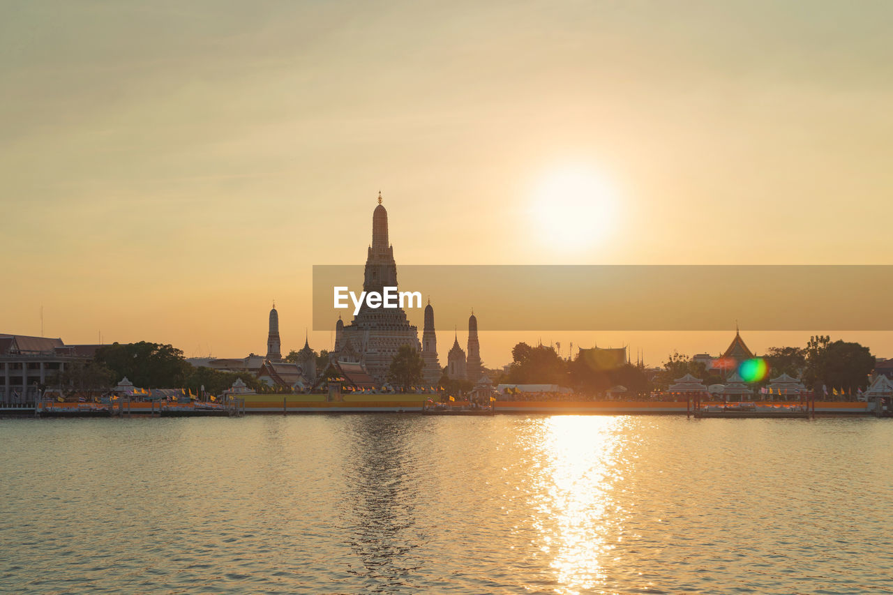 VIEW OF BUILDINGS AT WATERFRONT DURING SUNSET