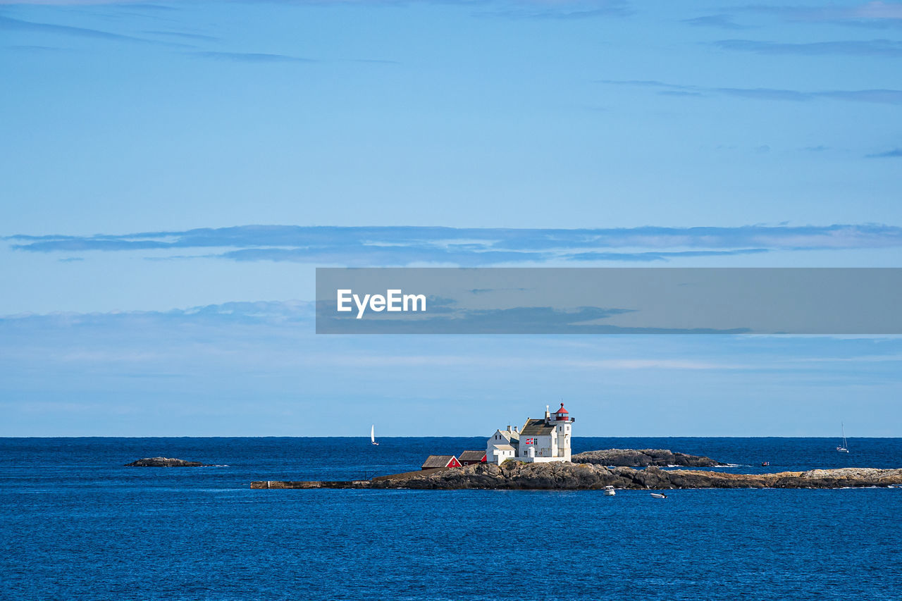 LIGHTHOUSE AMIDST SEA AGAINST SKY