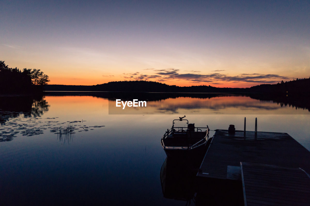 SILHOUETTE BOAT IN LAKE AGAINST SKY DURING SUNSET